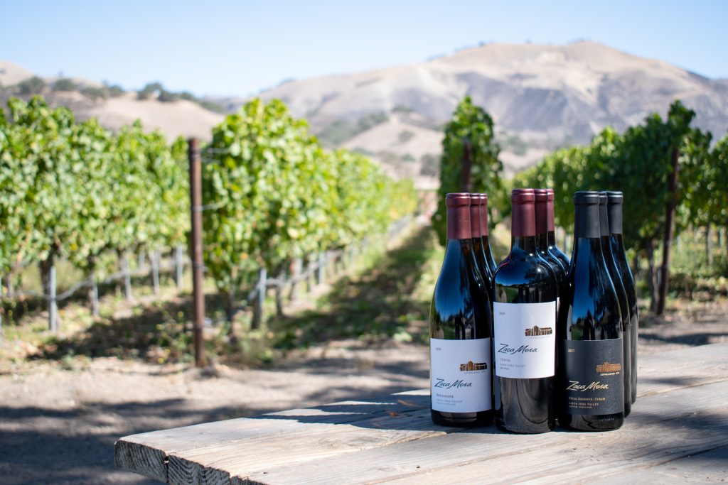 Six Zaca Mesa wines on a picnic table in front of the Grenache Blanc Vineyard